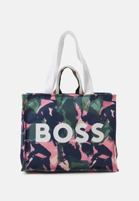 Bolsa de tela con un diseño abstracto en rosa, verde y azul marino, gran texto blanco "BOSS" y asas contrastantes en blanco y marrón.