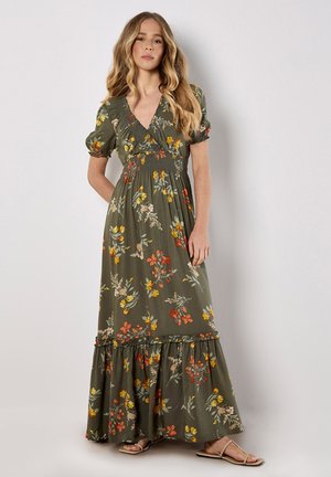 Maxikleid in Olivgrün mit floralen Druck in Gelb, Orange und Creme. Verfügt über kurze Puffärmel und einen rüschigen Saum. Glattes Material.