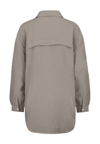 Long-sleeve, button-up beige shirt with a textured fabric, a collar, and a yoke detail at the back. Cuffed sleeves with buttons.