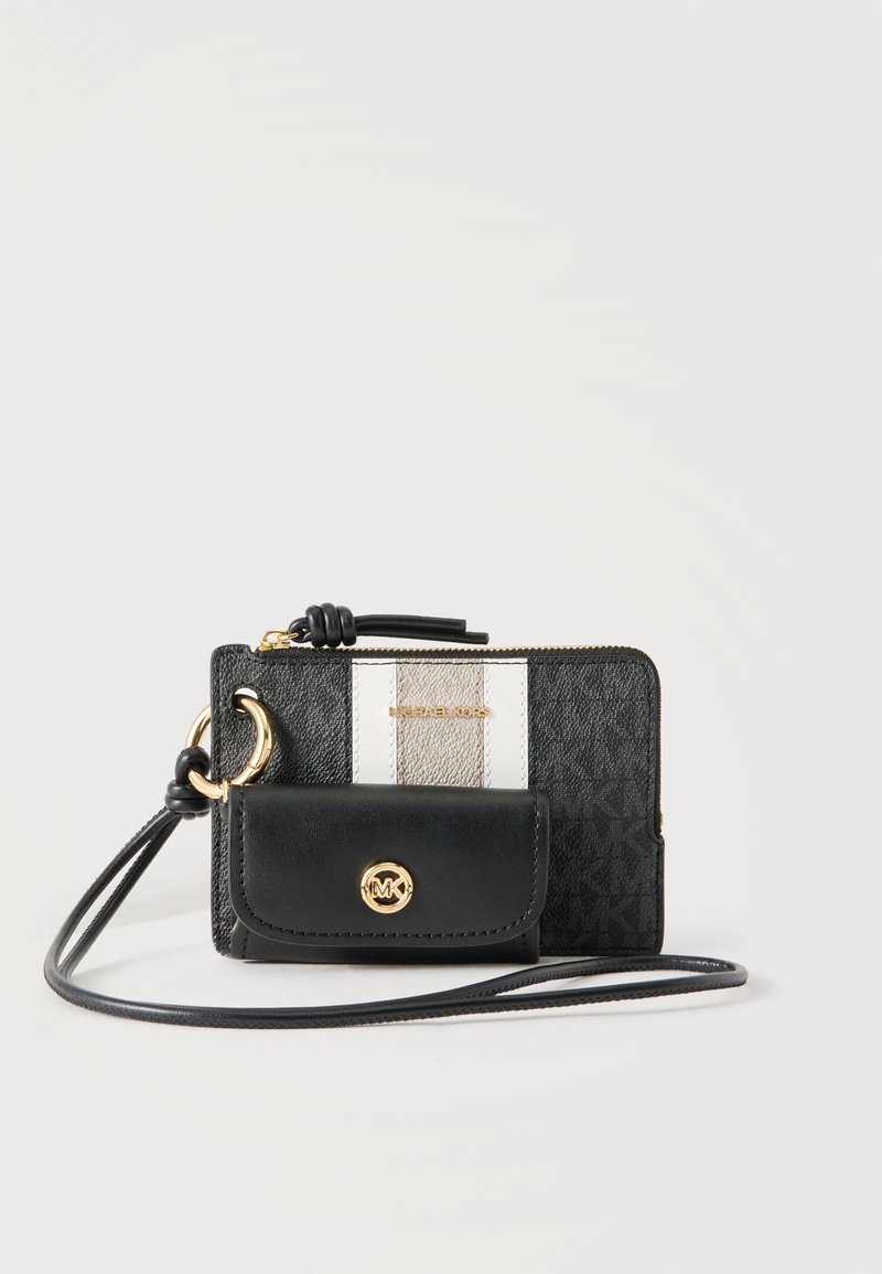 Portefeuille bracelet Michael Kors noir et gris avec emblème de logo doré, poche avant à rabat et sangle en cuir attachée sur fond blanc.