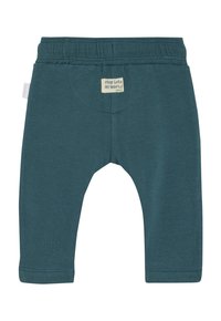 Pantalons en coton turquoise pour bébé avec une taille élastique douce et une petite étiquette portant l'inscription "entre dans mon monde" à l'arrière. Coupe régulière avec des coutures surpiquées.