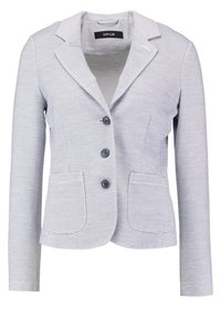 Blazer gris clair avec des rayures horizontales, des revers structurés, trois boutons et deux poches avant. Le tissu semble texturé. Étiquette de marque : OPUS.