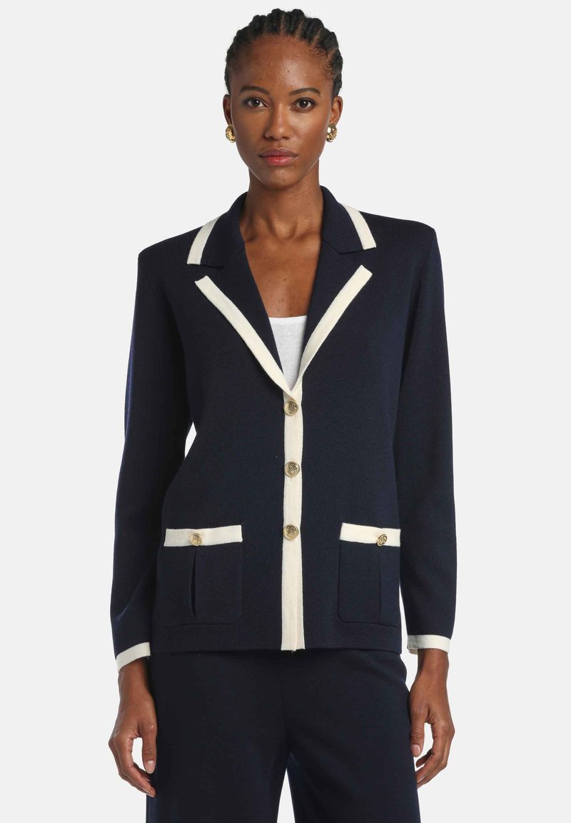 Navy blazer with cream trim, gold buttons, and two front pockets. Designed with a structured fit and notch lapels.