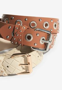 Two belts: a brown leather belt with silver studs and eyelets, and a white woven belt with a rose gold buckle.