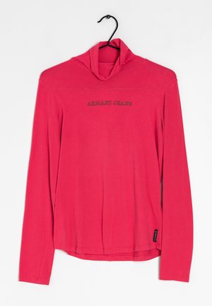 Chemise rouge à manches longues avec col roulé et l'inscription « ARMANI JEANS » imprimée sur la poitrine, suspendue à un cintre noir sur fond blanc.