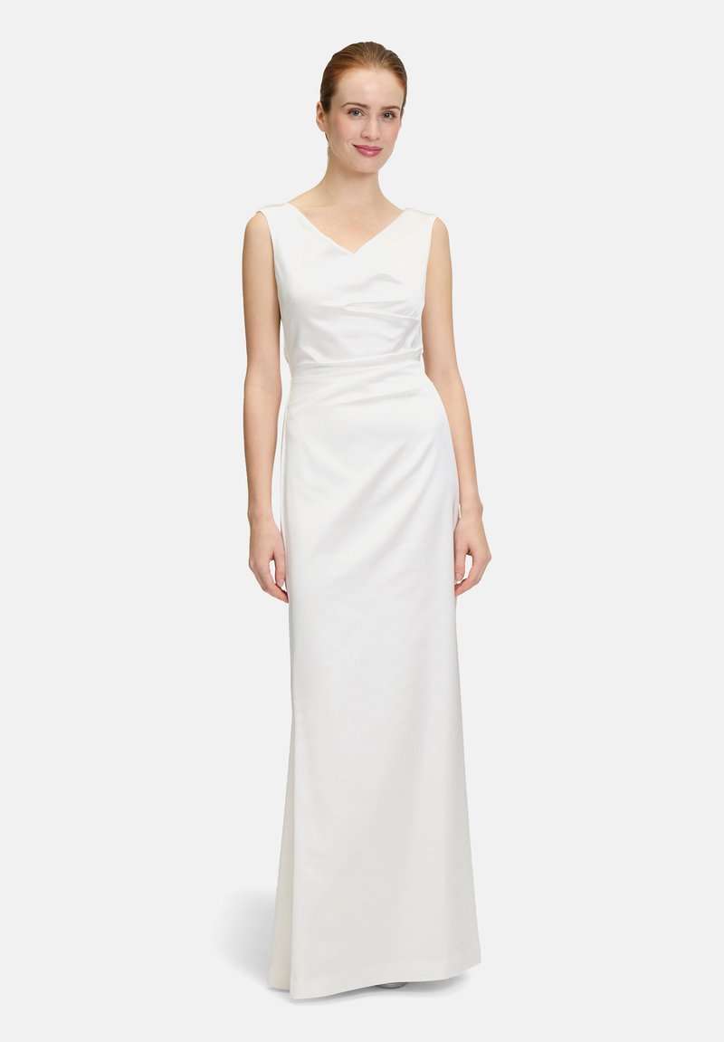 Robe blanche sans manches, longueur sol, avec un décolleté en V, texture de tissu lisse et un subtil détail de drapé autour de la taille.