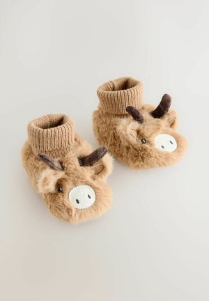 Chaussons en peluche beige avec un poignet en tricot, arborant un design de vache, un visage brodé et des cornes en tissu, offrant un look amusant inspiré des animaux.