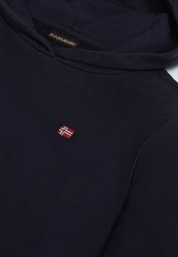 Felpa blu navy in tessuto morbido e textured, con una piccola bandiera norvegese ricamata sul petto. Design classico con cappuccio.