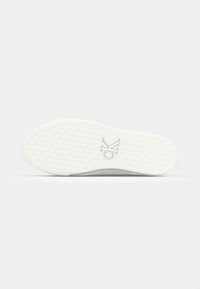 Suola di sneaker bianca con grip in gomma testurizzata, dotata di un'impronta del logo e bordi arrotondati. Il design è minimalista e piatto.