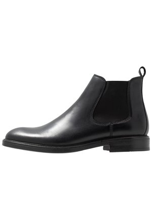 Botte Chelsea en cuir noir avec panneau latéral élastique, talon bas, bout rond et languette à l'arrière, vue de profil sur fond blanc.