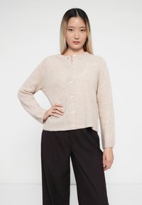 Ljusrosa cardigan med knäppning vid halsen, långa ärmar och korta ärmslut. Mjuk textur och subtilt horisontellt mönster synligt.