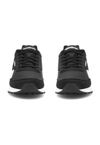 Čierne športové topánky so zvrškom z oka a semišu, vybavené plochými šnúrkami, bielou medzipodrážkou a textúrovanou podrážkou. Logo viditeľné na jazyku.