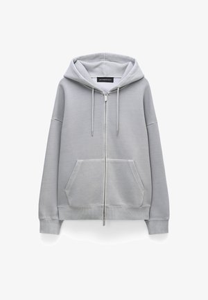 Lichtgrijze hoodie met rits, gemaakt van zachte stof, voorzien van een ruime voorzak, capuchon met trekkoord en geribbelde manchetten en zoom.