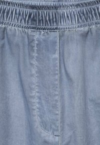 Svijetloplave hlače s elastičnim pojasom, sa bočnom džepom i glatkom, mekom teksturom, šivenim šavovima i jednostavnim dizajnom.