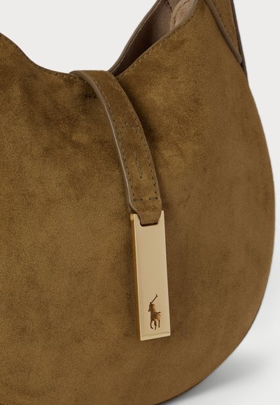 Smeša smeđe suède torba s zakrivljenim dizajnom, koja ima tamniju traku i zlatni oznaku s urezanim logotipom konja.