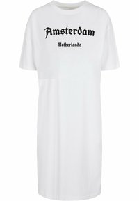 Rochie din bumbac alb, oversized, cu inscripții negre "Amsterdam" și "Olanda" într-un font îndrăzneț. Guler clasic rotund, mâneci scurte.