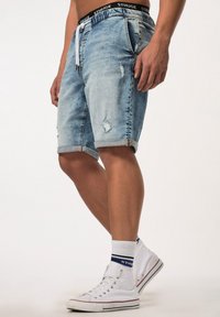 Denim shorts in lichtblauw met verouderde details, opgerolde omslagen, een trekkoord in de taille en subtiele branding op de elastische band.