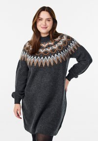 Robe pull en matériau tricoté de grande taille, de couleur gris foncé, avec un empiècement à motif en orange, blanc et noir. Elle présente un col montant et des poignets côtelés.