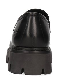 Zwarte leren schoen met een ronde neus en een dikke, gestructureerde rubberen zool met diepe profiel en zichtbare stiksels langs de rand.