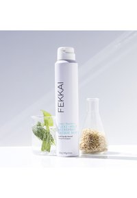 Fekkai Flexi-Hold Hairspray in a white spray can, with turquoise text. Two glass containers with mint leaves and rice grains nearby.