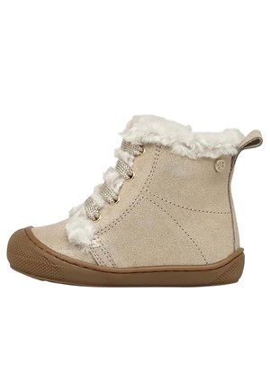 Beige ruskind børnestøvle med brun gummisål, hvid imiteret pelsforing og beige snørebånd, vist i sideprofil på hvid baggrund.