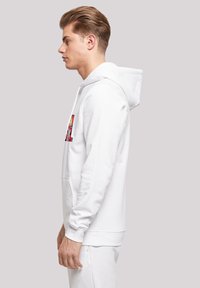 Balts kapucejums no kokvilnas maisījuma, ar priekšējo kabatu, ribotiem piedurkņu galiem un krāsainu apdruku uz krūtīm. Gluda faktūra.