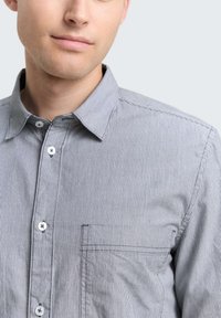 Gestreepte button-up shirt in grijstinten en wit, met een zak, een klassieke kraag en een gekreukt katoen materiaal.