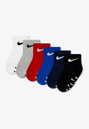 Έξι ζεύγη βρεφικές κάλτσες Nike σε λευκό, γκρι, κόκκινο, μπλε, ναυτικό μπλε και μαύρο, κάθε μία με το λογότυπο Nike Swoosh κοντά στο μανσέτι και τη σόλα.