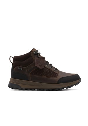 Bota de senderismo de cuero y textil marrón oscuro con puntera negra, suela gruesa con dibujo, soporte para el tobillo, ojetes metálicos y etiqueta de forro cálido.