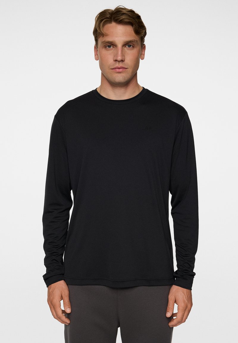Musta pitkähihaista T-paitaa, jossa on pyöreä kaula-aukko ja slim fit -leikkaus. Valmistettu sileästä, kevyestä kankaasta, jossa on huomaamaton logo rinnassa.