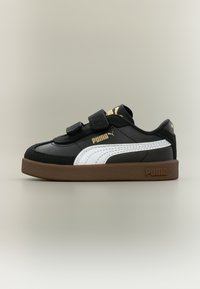 Μαύρο αθλητικό παπούτσι Puma με δύο λουράκια βέλκρο, λευκή ρίγα στο πλάι, χρυσά λογότυπα Puma και χοντρή καφέ σόλα, τοποθετημένο σε ουδέτερο φόντο.
