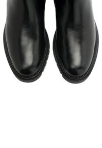 Bottines en cuir noir avec une finition brillante, bout arrondi et semelle texturée contrastante. Présente une couture décorative le long du bord.