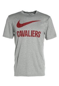 Camiseta gris de manga corta hecha de un tejido suave, con un gran logo rojo de Nike y la palabra "CAVALIERS" en letras rojas en negrita en el frente.
