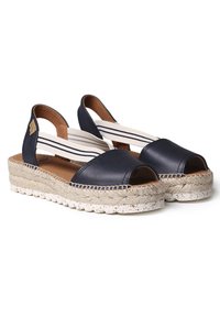 Navy leather espadrille sandals with open toe, striped elastic straps, and braided jute sole with white speckles.