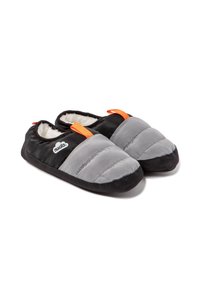 Pantuflas acolchadas en gris y negro con forro de piel de borrego, que presentan bucles de acento en naranja y una suela negra texturizada para mayor agarre. Logo de la marca visible.