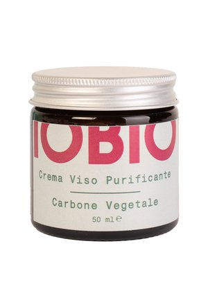 Barattolo di vetro marrone con un coperchio in metallo argentato. L'etichetta presenta un testo in grassetto rosa e verde che dice "Crema Viso Purificante" e "Carbone Vegetale." 50 ml.
