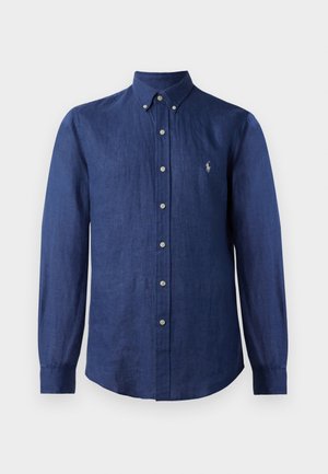 Camisa de manga larga azul marino hecha de lino, con cuello abotonado, que presenta un pequeño logotipo y cierres frontales con botones.