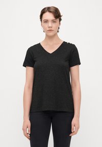 Sort V-hals t-shirt med korte ærmer, lavet af tekstureret stof med subtile guldfleks. Bemærk: dekorative knapper på skuldre detaljen.