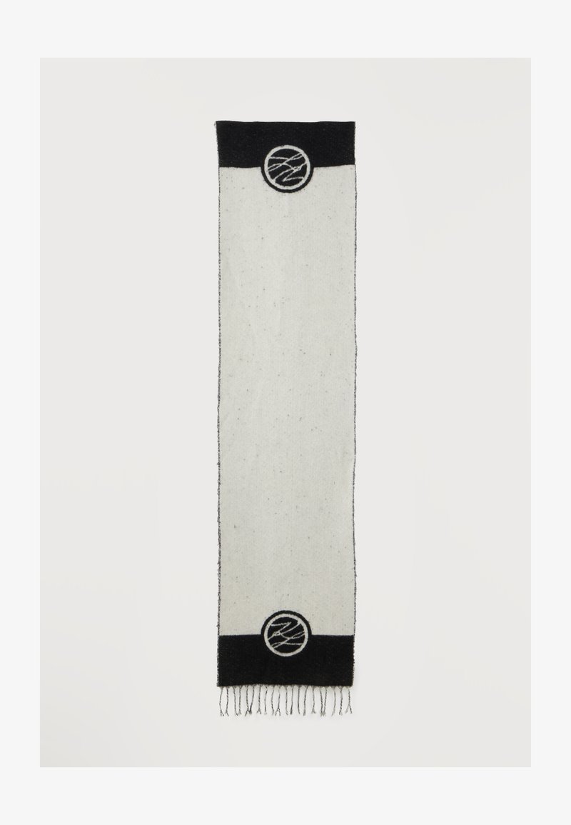 Longue écharpe rectangulaire blanche avec extrémités noires, chaque extrémité présentant un emblème circulaire avec un motif abstrait en lignes et des franges en bas.