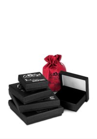 Cinq boîtes à bijoux noires avec des surfaces texturées, de tailles variées, empilées avec un sac en satin rouge avec cordon. L'intérieur est en velours noir.
