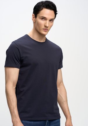 Camiseta de manga corta color azul marino con cuello redondo, hecha de un suave material de algodón. Presenta un diseño ajustado y detalles de costura sencillos.