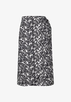 Jupe imprimée animal noir et blanc avec un design enveloppant, dotée d'un lien sur le côté et d'une texture de tissu lisse, tombant au niveau des cuisses.