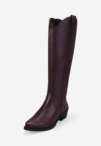 Bota de cuero burdeos brillante hasta la rodilla, con puntas afiladas y tacón cuadrado bajo. Presenta un borde superior en forma de ola y un detalle de costura en contraste.