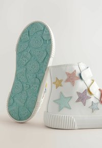 Weiße High-Top-Sneaker mit glitzernden Sternenverzierungen in Pink, Blau, Gelb und Gold; strukturierte Gummisohle mit einem lebensmittelthemenbezogenen Muster.