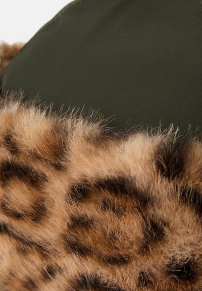 Πράσινο ύφασμα με υφή από καφέ και μαύρο λεοπάρ σχέδιο faux fur στο άκρο, με απαλά, μακριά νήματα που έρχονται σε αντίθεση με το λείο υλικό.