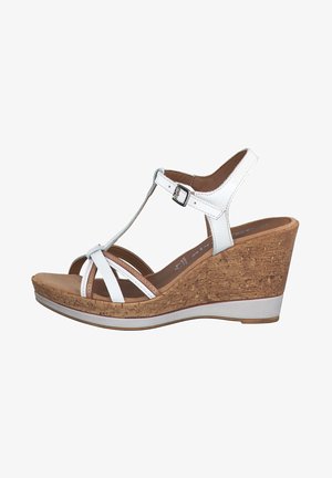 White wedge sandals with cork midsole, adjustable ankle strap, and cross straps. Smooth upper texture with a solid base and subtle contrast accents.