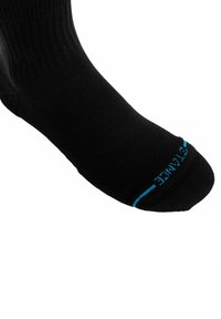 Calzino sportivo nero con una texture liscia, punta e tallone rinforzati. Dettaglio blu vicino alla punta con il marchio. Design di altezza alla caviglia.
