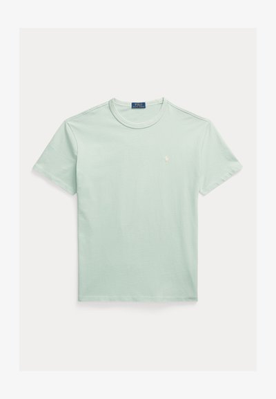 T-shirt de algodão verde claro com decote redondo, mangas curtas e um pequeno logótipo branco no peito. Textura suave e design simples.