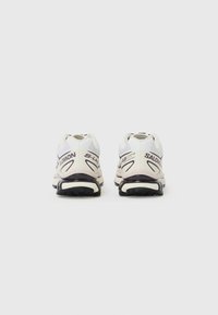 Scarpe da corsa Salomon S-Lab XT6 bianche e viola con suola in gomma texturizzata, tallone ammortizzato e design elegante.