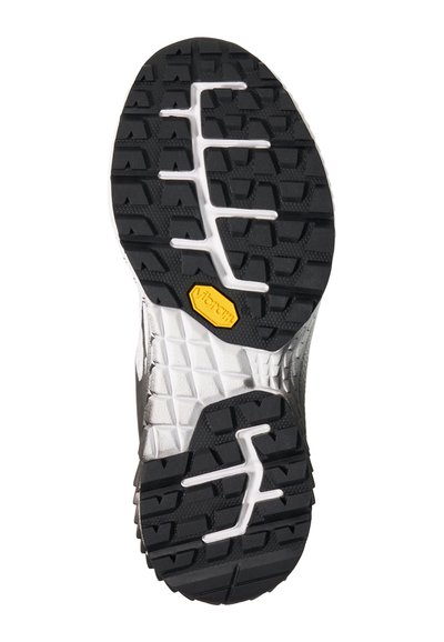 Semelle de chaussure avec motif de bande de roulement noir et blanc, avec un logo Vibram jaune près du centre pour la traction et la durabilité.